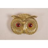 A novelty brass vesta case in the form of an owl head with glass eyes, 2" wide