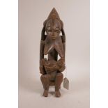 An African carved hardwood figure of a mother and child, 12½" high