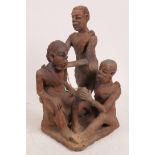 An African terracotta figure group of depicting a tooth extraction, 10" high