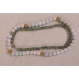 A string of tri-colour jade beads, and another string of jade beads, longest 22"