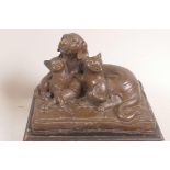 A bronze figurine of a dog and two cats lying on cushions, 6½" long