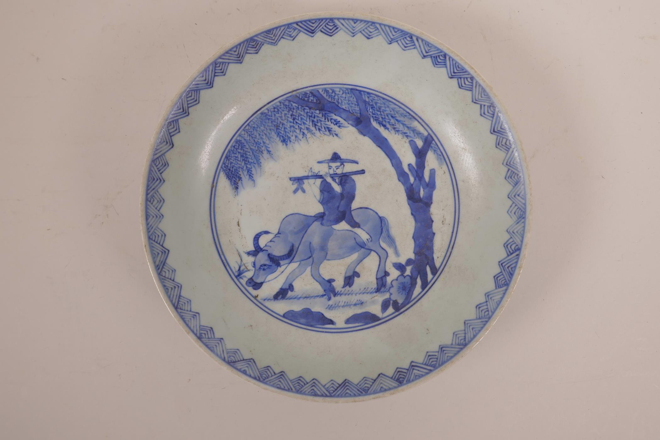 A Chinese blue and white porcelain dish decorated with a figure riding an ox, 8½" diameter