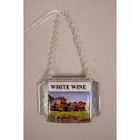 A silver plated wine bottle label set with a cold enamel plaque depicting a vineyard and labelled '