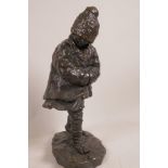 An Eastern European bronze figurine of a child wrapped up against the cold, 12" high, signed R.P.