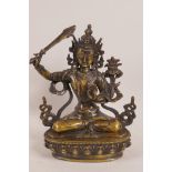 A Tibetan bronze figure of Buddha wielding a flaming sword, 9" high