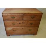 A pine chest of two short and two long drawers with brass drop handles on shaped supports, 27½" high