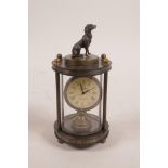 A brass cased desk clock with an open movement and a knop in the form of a dog, 5" high