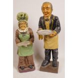 Two composition figurines of a butler and cook, both holding trays, 14" high