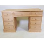 A pine nine drawer pedestal desk, 54" x 23", 32" high