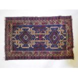 A Persian rug with geometric designs on a blue field, 33" x 51"