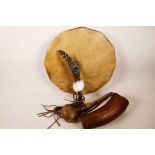 A Native American tribal drum and beater, a horn beaker and a ceremonial feather whisk, drum 12" dia