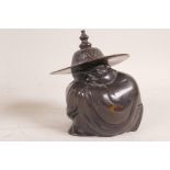 A Japanese bronze figurine of a man in a large hat squatting on the ground, 6" high