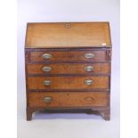 A Georgian oak fall front bureau, with fitted interior over four long drawers with original plate