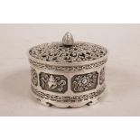 A Chinese white metal trinket box and pierced cover, the sides decorated with the emblems of the