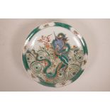 A Chinese famille verte porcelain charger decorated with a dragon chasing the flaming pearl, 6