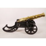 A heavy C19th brass table cannon on a pierced cast iron carriage