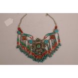 A Tibetan white metal, turquoise, agate and coral necklace with a large central medallion, 21" long