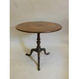 A Georgian mahogany tilt top table on a carved column and tripod cabriole legs, with a one piece