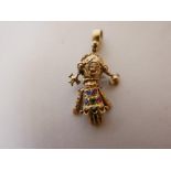 A 9ct gold charm pendant in the form of a rag doll, set with diamonds, emeralds and rubies, 1" long,