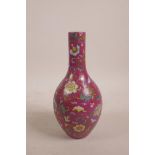 A Chinese polychrome porcelain bottle vase, with all over bat and floral decoration on a puce