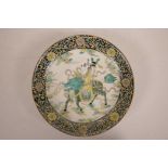 A Chinese famille verte porcelain dish decorated with a child riding a mythical creature, 6
