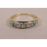 A 9ct gold half eternity diamond and emerald ring with three emeralds interspersed with four white