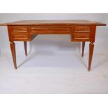 A French mahogany five drawer desk, with brass mouldings, slides to each end, and inset leather top,