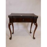 A Georgian, well figured, rosewood veneered, three fold games table with two gilt tooled leather