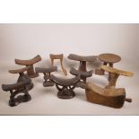 A collection of African carved wood headrests and stools, largest 7" high