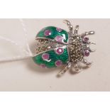 A 925 silver brooch in the form of a ladybird with green enamel wings and stone settings, 1"