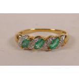 A 9ct gold, emerald and diamond ring, inset with three angled marquise emeralds, with alternate rows