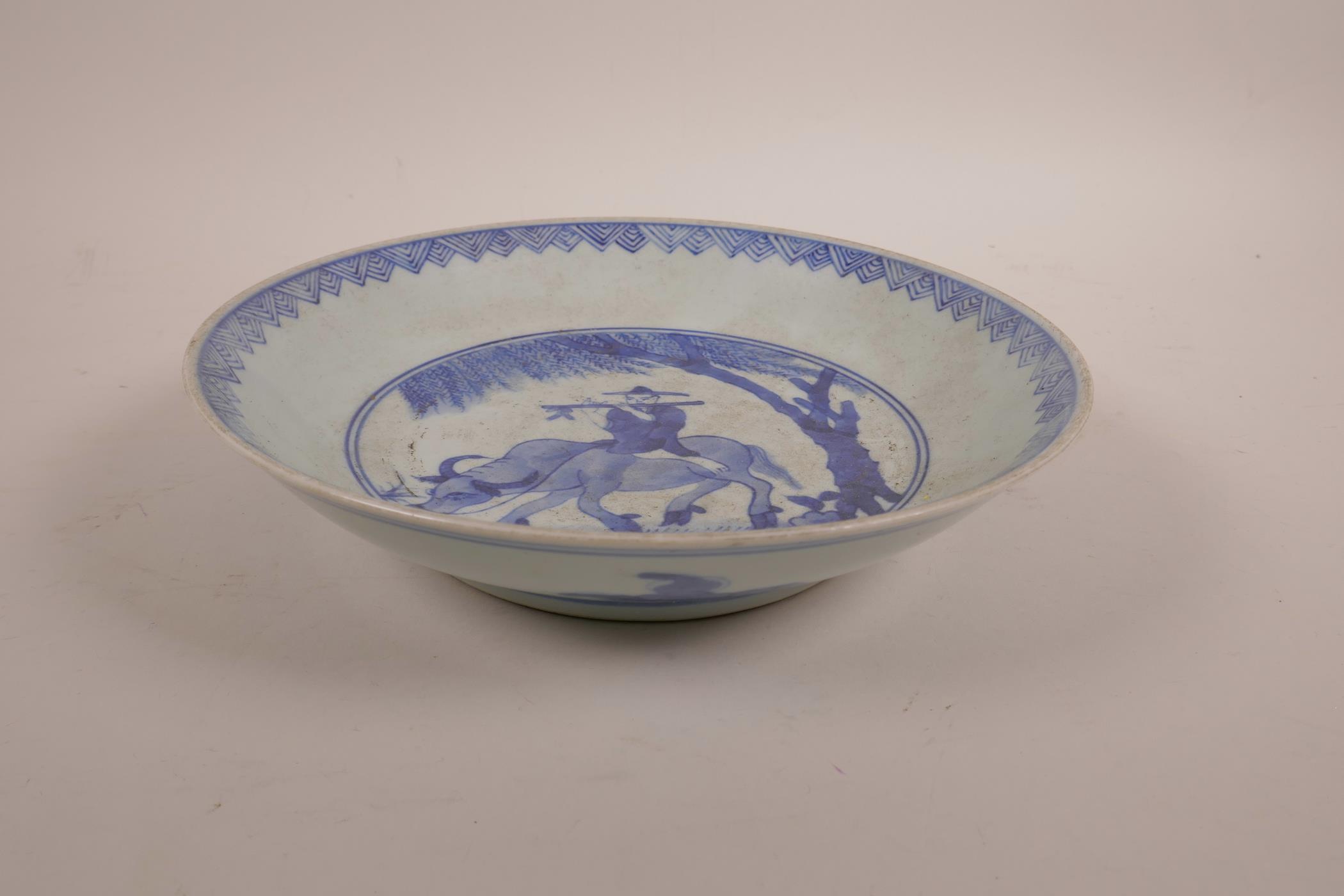 A Chinese blue and white porcelain dish decorated with a figure riding an ox, 8½" diameter - Image 2 of 3