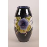 A Moorcroft style blue glazed pottery vase with floral decoration, 12" high