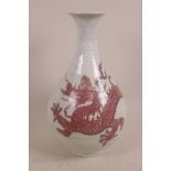 A Chinese porcelain vase of bulbous form, decorated with embossed clouds and a fiery dragon in