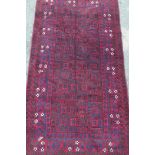 A red ground Middle Eastern Kashan rug with floral decorated border, 41" x 74"