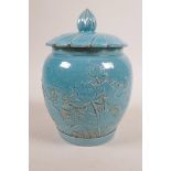 A Chinese turquoise glazed porcelain jar and cover with raised lotus flower decoration, impressed