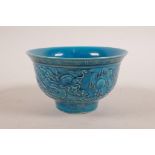 A Chinese blue glazed porcelain rice bowl with raised decoration of dragons chasing the flaming