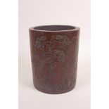 A Chinese carved bamboo brush pot decorated with a sage, deer and bat in a landscape, character