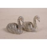 A pair of silver plated condiments in the form of swans, 2" long