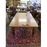 An early Victorian mahogany wind out dining table with two extra leaves, with a patent winder by