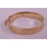 A hallmarked 9ct gold bangle with engraved decoration (16.7 grams)