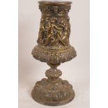 A bronze pedestal urn with embossed decoration of Bacchanalian figures, 12" high