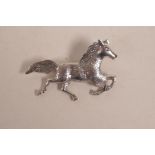 A 925 silver brooch in the form of a horse at gallop, 2" wide