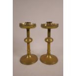 A pair of brass candlesticks in the Gothic style, 9" high x 4" wide
