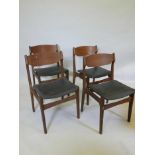 A set of four mid century teak dining chairs with black vinyl seats
