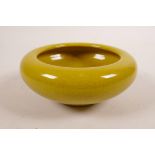 A Chinese mustard yellow crackle glazed porcelain bowl with a rolled edge, 6 character mark to base,