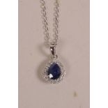 An 18ct white gold, pear shaped pendant necklace set with a sapphire encircled by diamonds