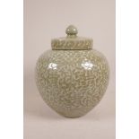 A Chinese celadon crackle glazed porcelain jar and cover decorated with auspicious symbols, 10½"