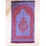 A Turkish blue and red prayer rug with scrolling floral decoration, 44" x 27"