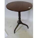 A tilt top mahogany wine table raised on a turned column and tripod supports, 28" high x 20"